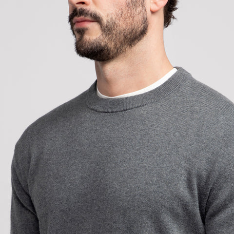 A man wearing the Anytime Crewneck Sweater Medium Heather Gray outdoors