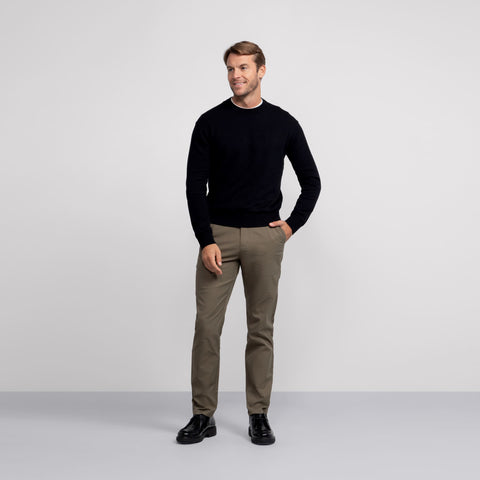 A man in the Anytime Crewneck Sweater True Black, side view.