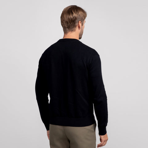 A man wearing the Anytime Crewneck Sweater in True Black from behind.
