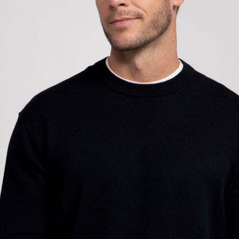 A man in the Anytime Crewneck Sweater True Black, lifestyle shot.