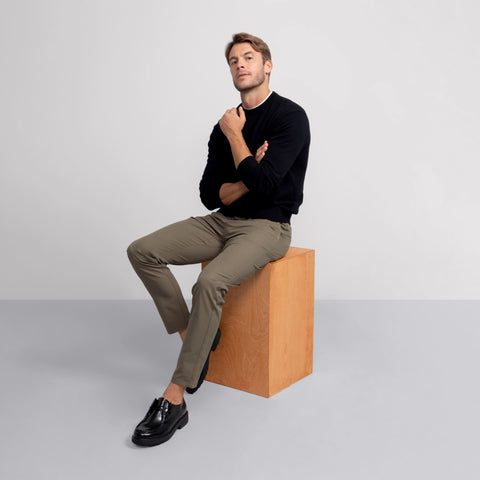 A man wearing the Anytime Crewneck Sweater in True Black outdoors.