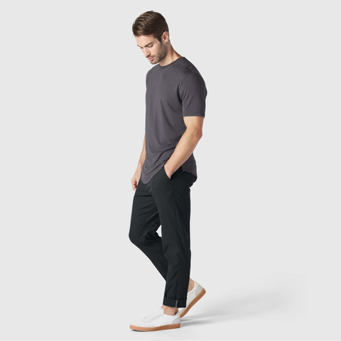 A man in the Anytime Tee Charcoal Gray, side view.