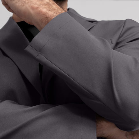 A man in the Jetsetter Blazer Charcoal Gray in a professional setting