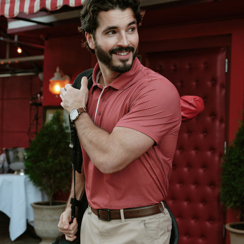 A man in the Clubhouse Pique Polo Red Brick line, outdoor setting