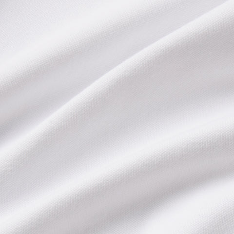 A man wearing the Clubhouse Pique Polo in True White in everyday setting.