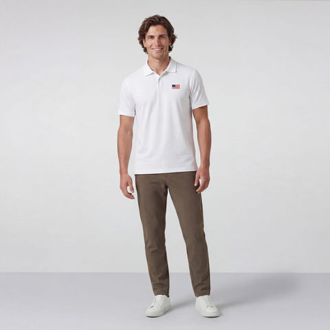 A man wearing the Clubhouse Pique Polo USA Flag in True White.