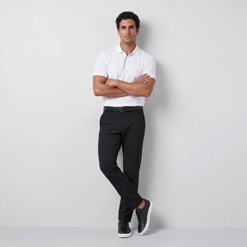 A man in the Clubhouse Performance Polo White Driveline, lifestyle shot.