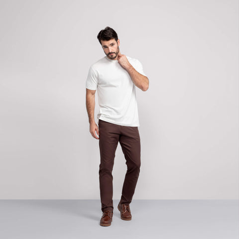 A model wearing the Jetsetter Tech Pant Slim Fit in Bourbon Brown.