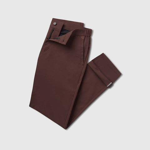 The Jetsetter Tech Pant Slim Fit in Bourbon Brown, folded on white background.