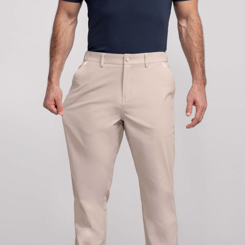 A man in the Jetsetter Tech Pant Relaxed Fit Oak Khaki, sitting outdoors