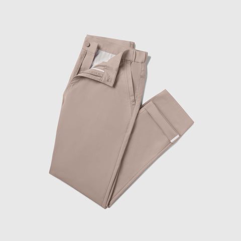 The Jack Archer Jetsetter Tech Pant Slim Fit in Oak Khaki, a comfortable and stylish pair of light beige dress pants, is neatly folded on a plain white background.