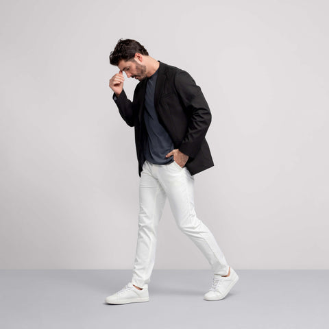 A man in the Jetsetter Tech Pant Slim Fit True White, sitting outdoors