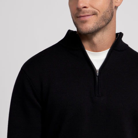 A man wearing the Jetsetter Quarter-Zip Sweater in True Black outdoors.