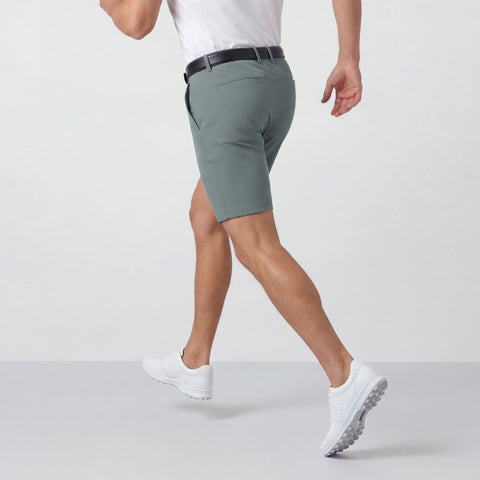 A man sitting wearing the Jetsetter Tech Short 7 inches in Storm Green