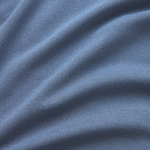Close-up of soft, light blue fabric with gentle, diagonal folds and a smooth texture—this breathable crewneck Jetsetter Tee creates subtle shadows and highlights, ideal for comfort whether traveling or working out.