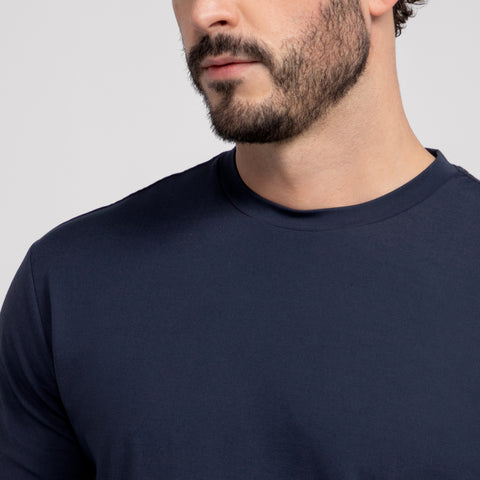 A close-up of a man wearing the Jack Archer Jetsetter Tee in Deep Blue, highlighting his beard and lower face, against a neutral light gray background.