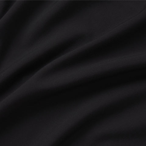 A close-up of the Jetsetter Tee -- True Black by Jack Archer shows smooth black fabric with soft folds and shadows, highlighting its subtle texture and making it ideal for a sleek, travel-ready crewneck look.