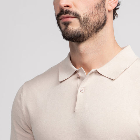 A man wearing the Legacy Polo Sweater in Beige outdoors.