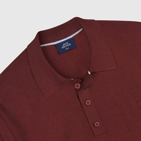 A man wearing the Legacy Resort Polo in Maroon, lifestyle setting.