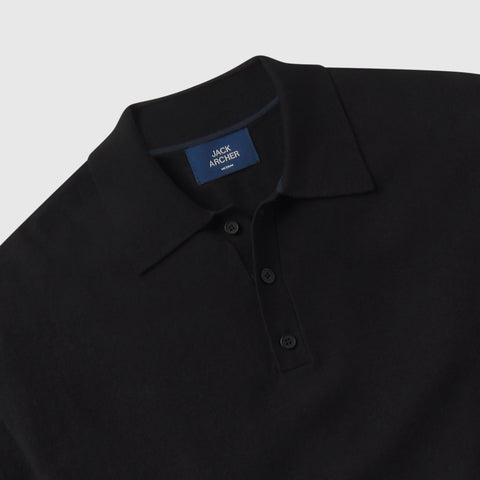 A man in the Legacy Resort Polo True Black, outdoor setting.