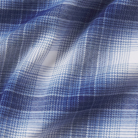 A man in the Anytime Plaid Shirt, Navy Classic Plaid, seated