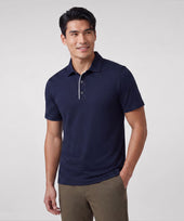 A man wearing Jack Archer Clubhouse Performance Polo in Navy Microdot against a light background.