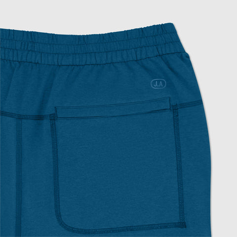 A man wearing the Clubhouse Range Jogger in Pacific Blue outdoors