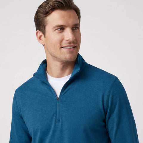 A man wearing the Clubhouse Range Quarter-Zip in Pacific Blue outdoors
