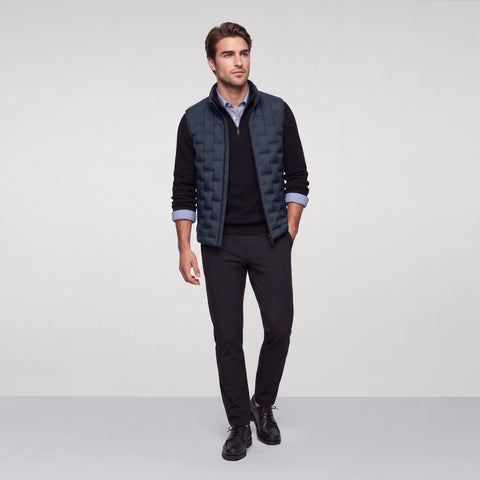 Deep blue quilted Drive vest worn with a black quarter-zip and black trousers, full length.