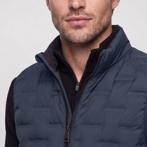 Close-up of the stand collar and front zip on the deep blue quilted Drive vest.