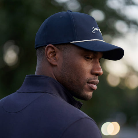A man wearing the Archer Signature Hat in Navy on the golf course