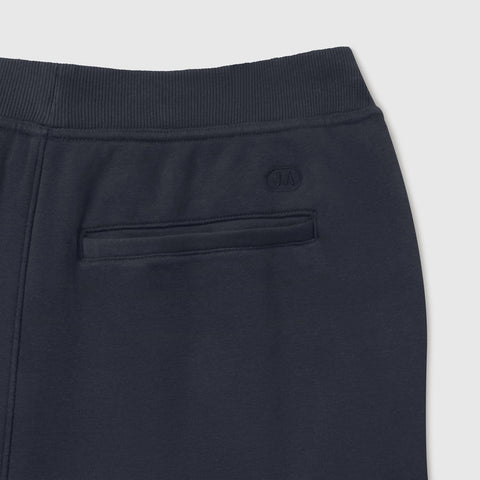 Close-up of the ribbed waistband and embroidered J.A back pocket on midnight navy sweatpants.