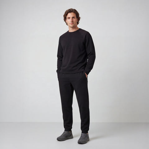 A man wearing the Sandwash Crewneck in True Black, side view.