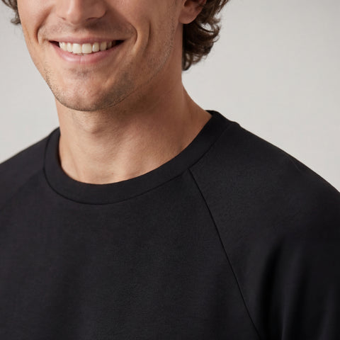 A man wearing the Sandwash Crewneck in True Black outdoors.
