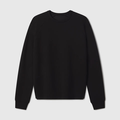 A man wearing the Sandwash Crewneck in True Black in casual setting.