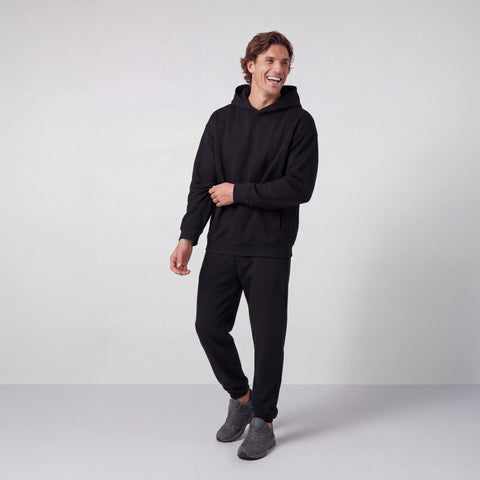 The Sandwash Hoodie True Black shown from the side on a model