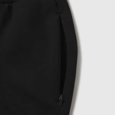 Man wearing the Sandwash Jogger in True Black indoors